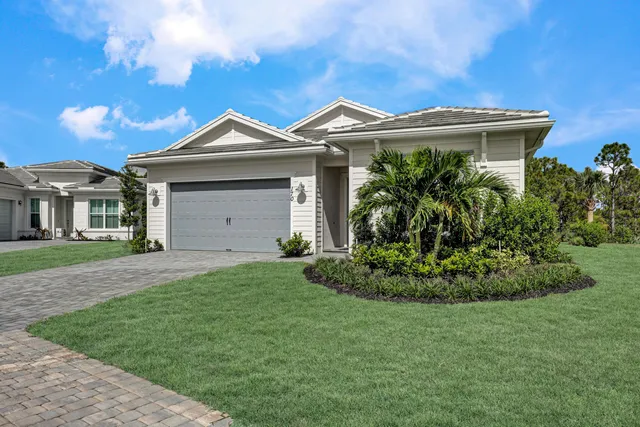 a front view of a house with a garden and plants