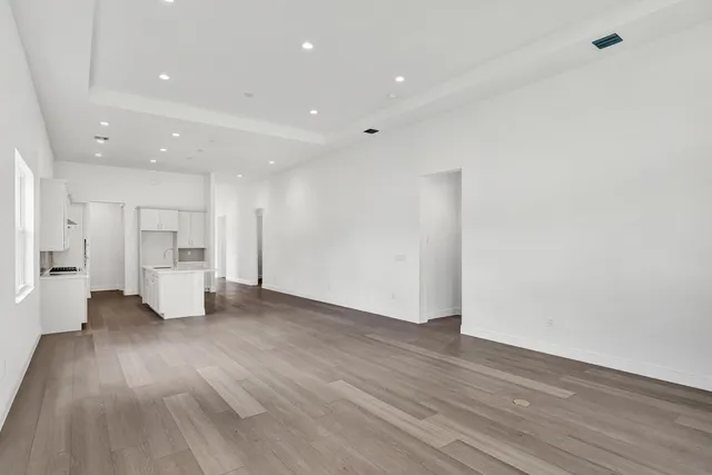 a view of an empty room with wooden floor