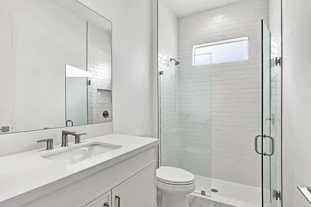 a bathroom with a granite countertop sink toilet and shower