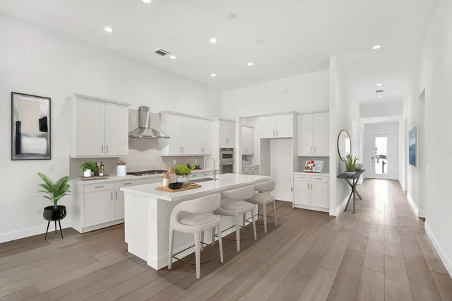 a kitchen with stainless steel appliances a table and chairs in it