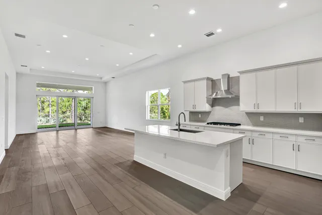 a kitchen with a sink window and cabinets