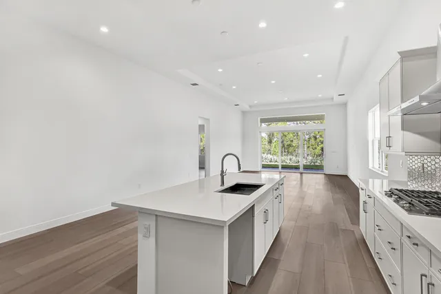 a kitchen with granite countertop a sink stove and refrigerator