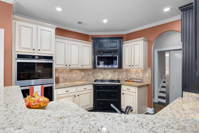 a large kitchen with stainless steel appliances granite countertop a lot of counter space and a sink