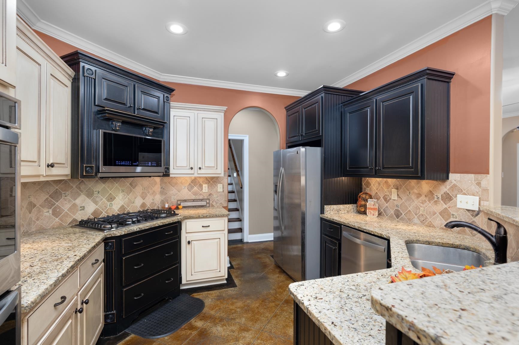 54 Palmer Cove Atoka, TN 38004 - Photo 11 of 40 Kitchen featuring arched walkways, ornamental molding, stainless steel appliances, light stone countertops, and recessed lighting