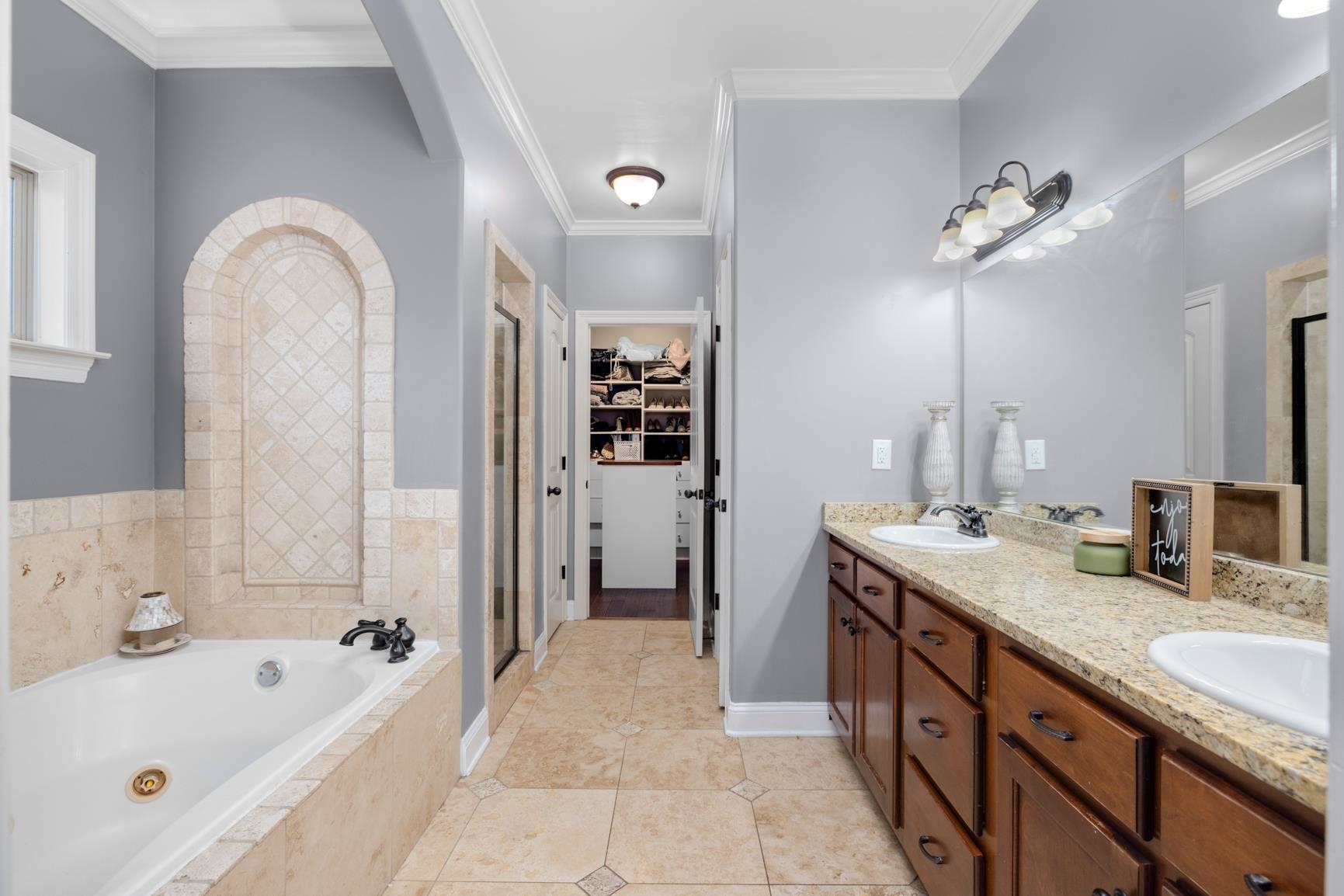 54 Palmer Cove Atoka, TN 38004 - Photo 16 of 40 Bathroom with a stall shower, a tub with jets, double vanity, a walk in closet, and ornamental molding