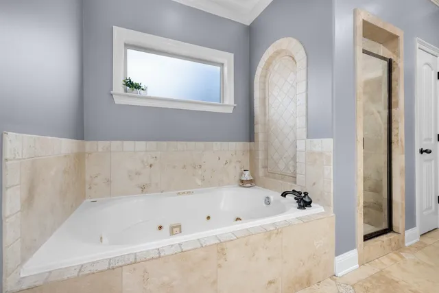 a bathroom with a tub a double vanity sink and a mirror