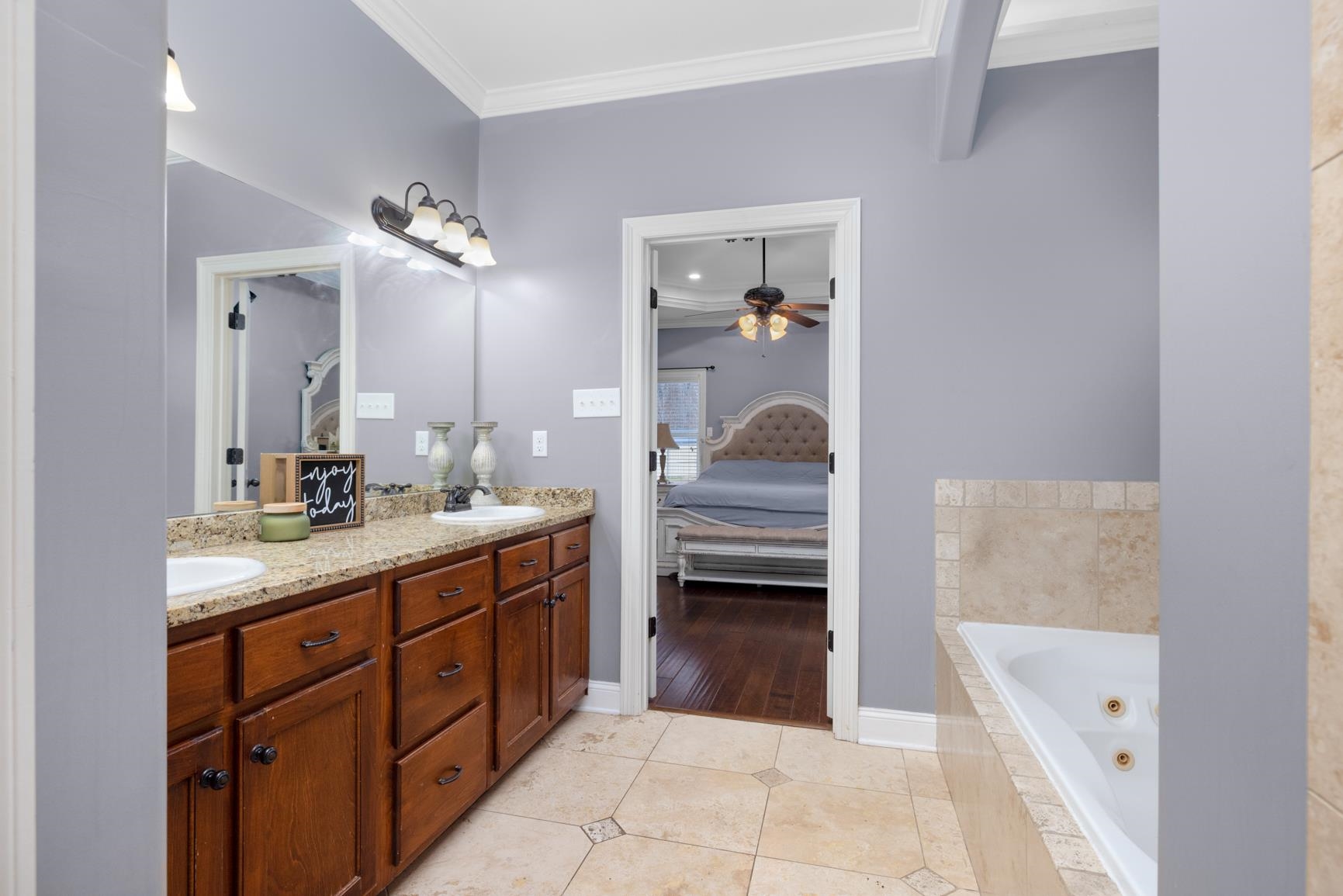 54 Palmer Cove Atoka, TN 38004 - Photo 19 of 40 Ensuite bathroom with ornamental molding, double vanity, a tub with jets, light tile patterned floors, and a ceiling fan