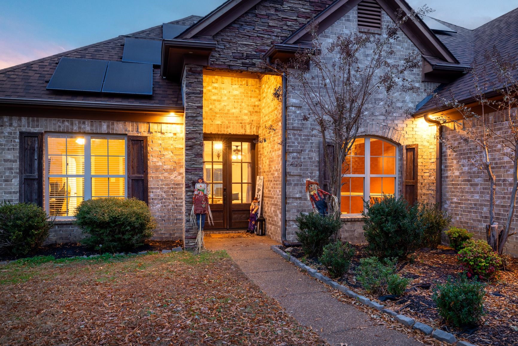 54 Palmer Cove Atoka, TN 38004 - Photo 37 of 40 Exterior entry at dusk with solar panels, french doors, brick siding, and roof with shingles