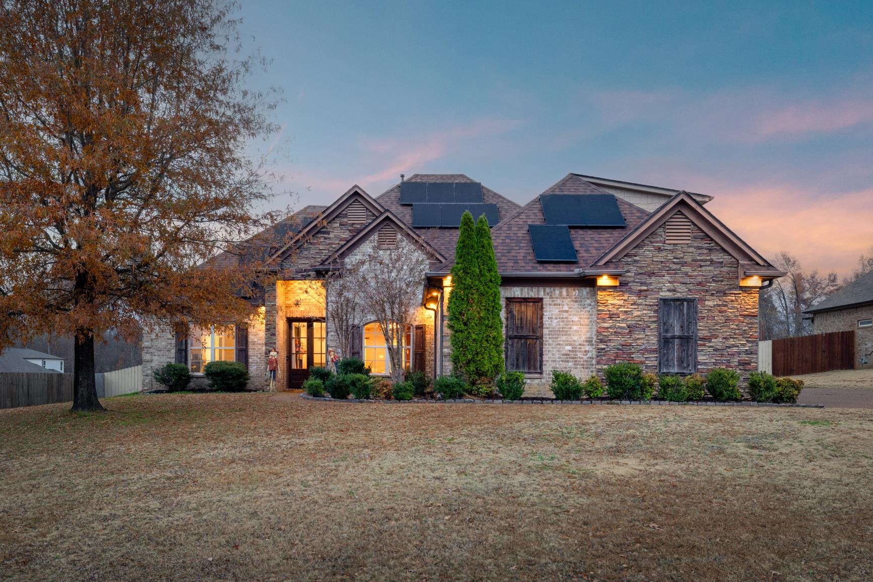 54 Palmer Cove Atoka, TN 38004 - Photo 39 of 40 View of front of house featuring roof mounted solar panels, stone siding, and a shingled roof