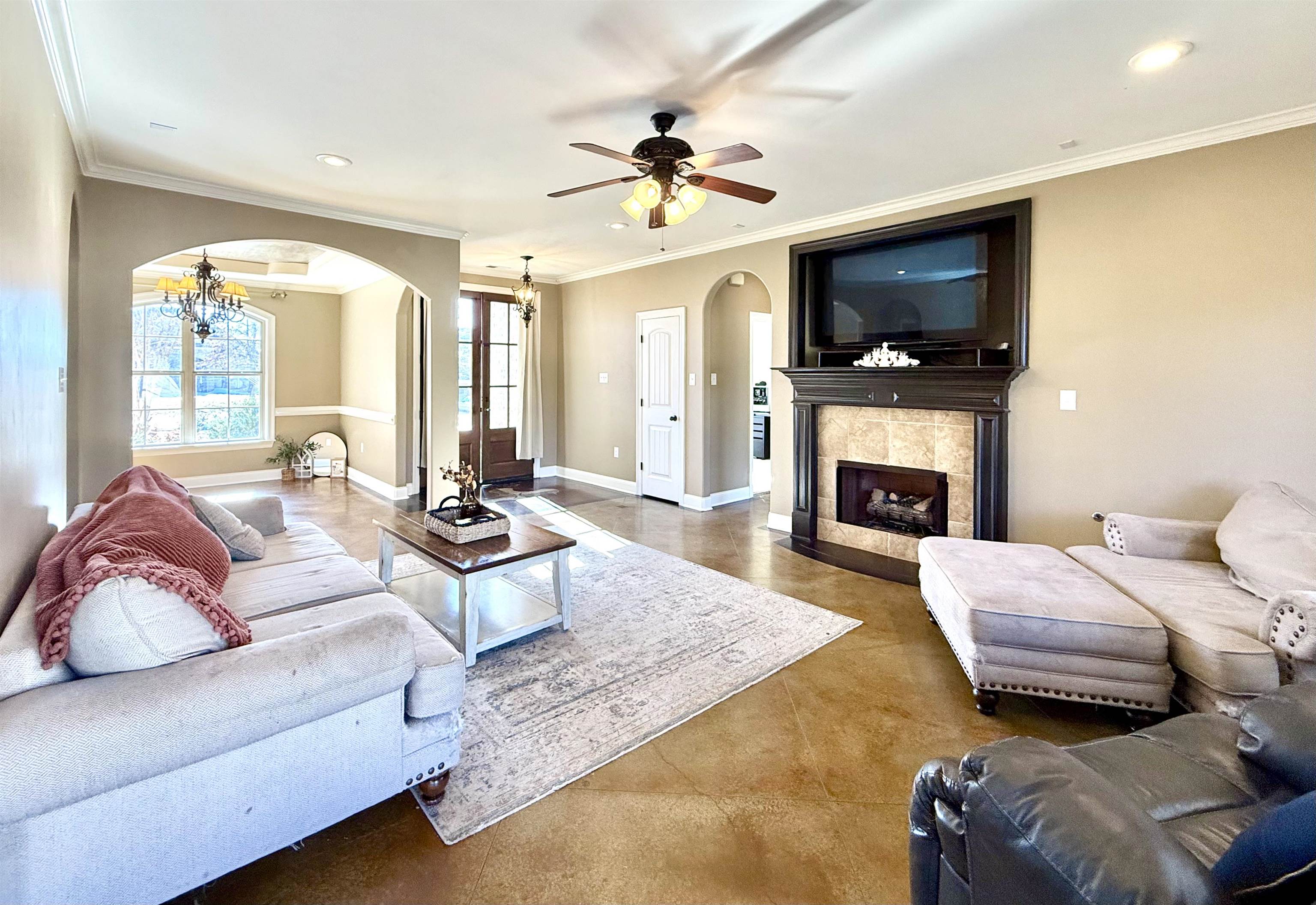54 Palmer Cove Atoka, TN 38004 - Photo 8 of 40 Living area with arched walkways, finished concrete floors, ornamental molding, suspended lighting, and a tile fireplace
