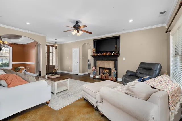 a living room with furniture a flat screen tv and kitchen view