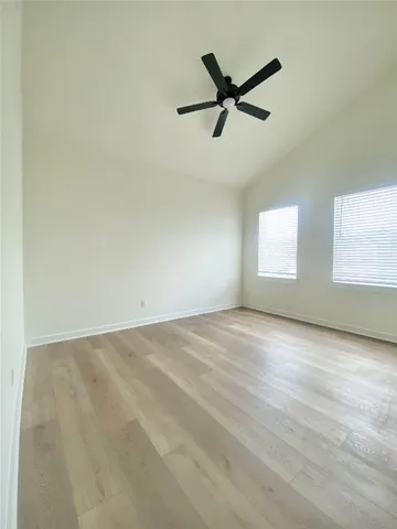 a view of a big room with wooden floor and windows