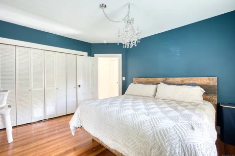 a large bed sitting in a spacious bedroom next to a chandelier