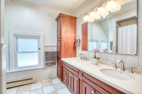 a bathroom with a double vanity sink a mirror and a shower