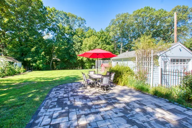 a view of a patio with a table and chairs under an umbrella