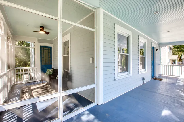 a view of a hallway with wooden floor and windows
