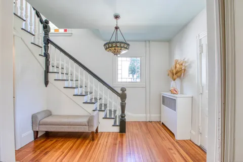 a view of entryway and hall with wooden floor