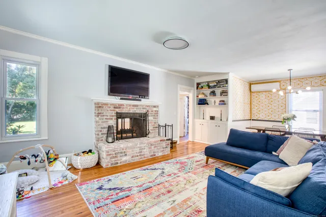 a living room with furniture a flat screen tv and a fireplace