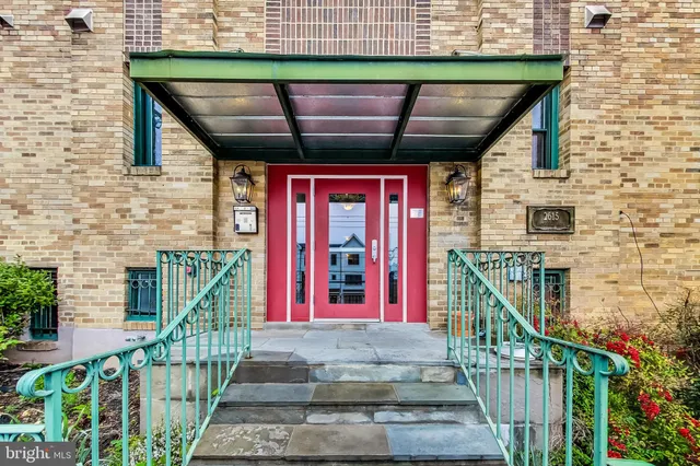 a front view of a house with glass windows and stairs