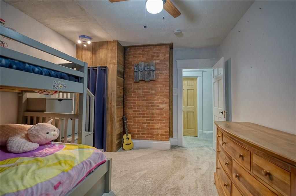 629 George Street Coraopolis, PA 15108 - Photo 15 of 25 Bedroom 3 features exposed brick wall and newer carpeting and 6 panel door.