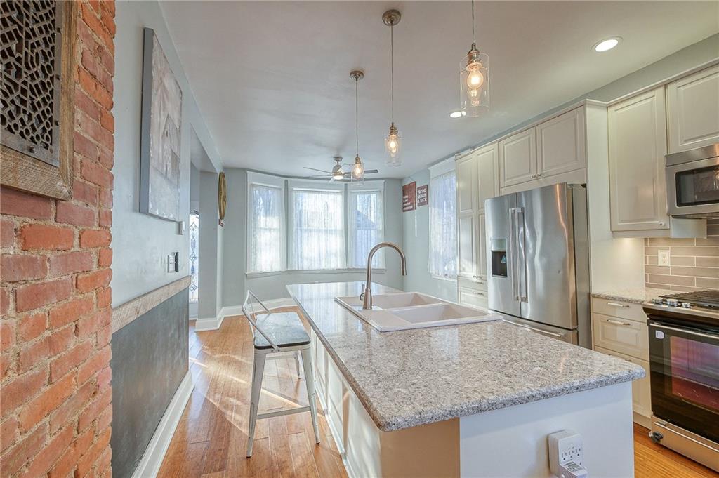 629 George Street Coraopolis, PA 15108 - Photo 5 of 25 Exposed brick accents the large kitchen with newer appliances and completely updated kitchen.