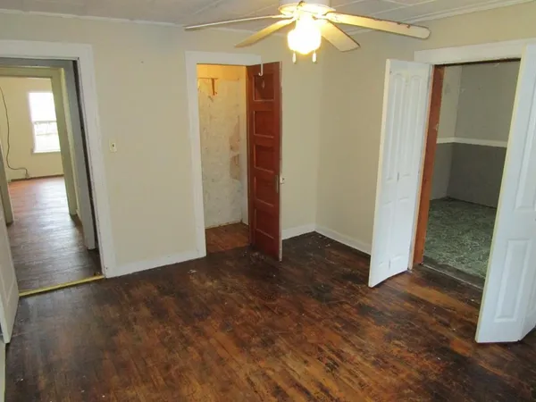 an empty room with wooden floor and cabinet
