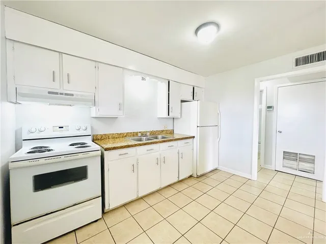 a view of a kitchen with wooden floor a ceiling fan and window