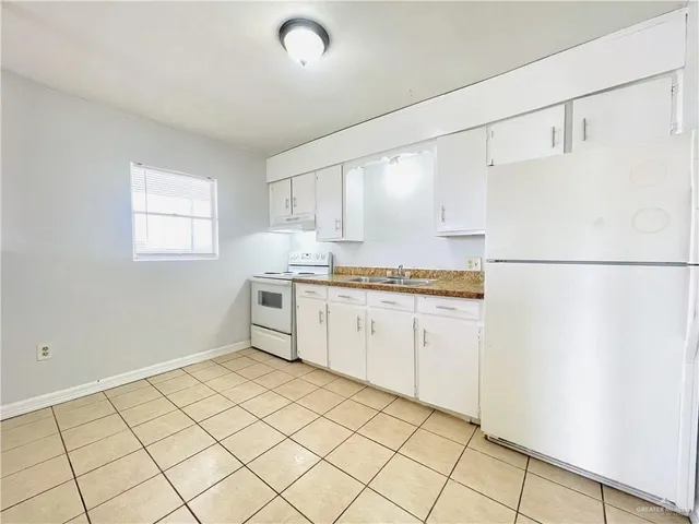 a view of a kitchen with wooden floor and appliances