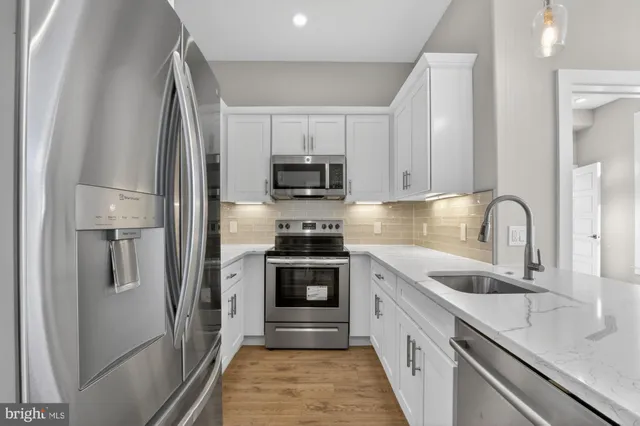 a kitchen with white cabinets and stainless steel appliances