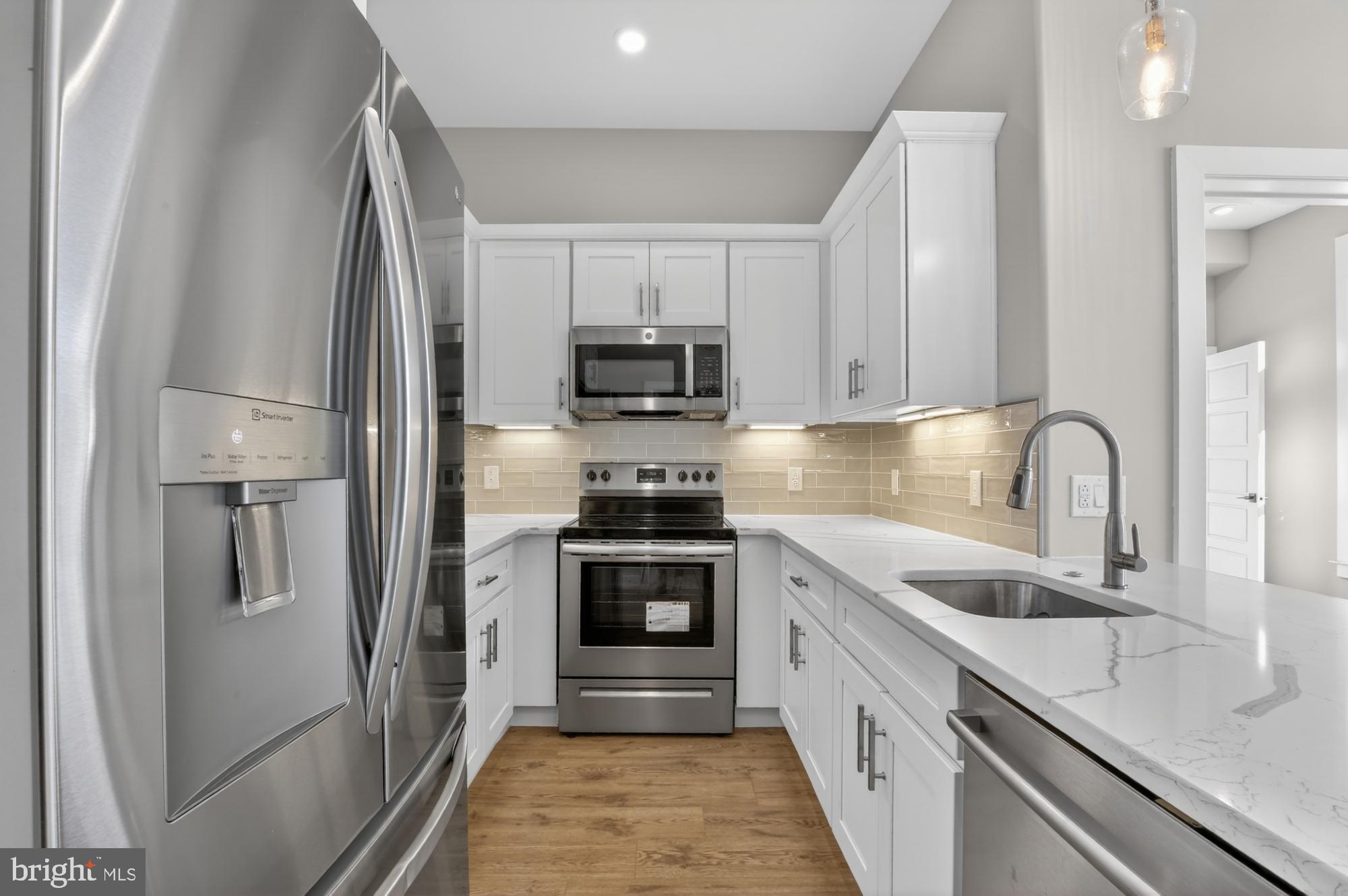 a kitchen with white cabinets and stainless steel appliances