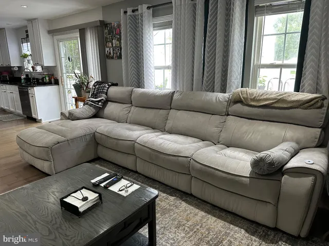 a living room with furniture and floor to ceiling windows