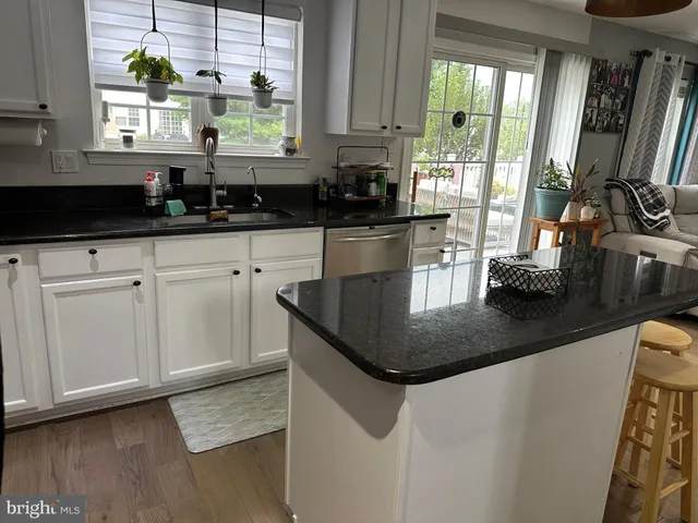 a kitchen with granite countertop a sink a stove and cabinets