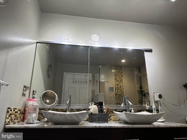 a bathroom with a granite countertop sink a toilet and a mirror