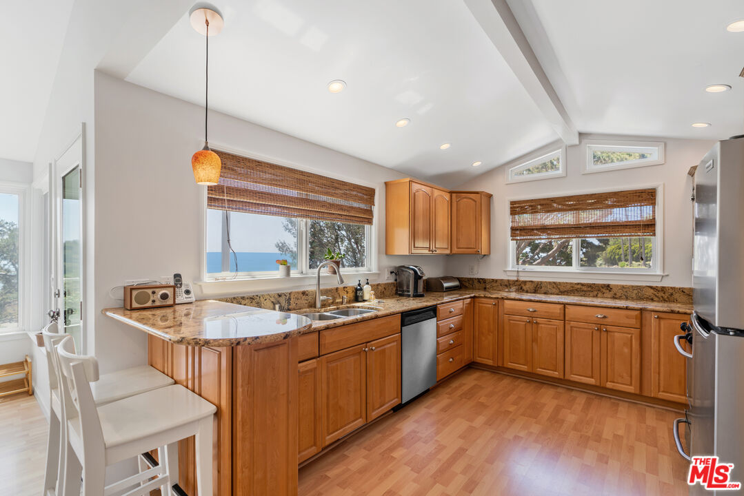 99 Paradise Cove Road Malibu, CA 90265 - Photo 5 of 26 a kitchen with sink stove and cabinets