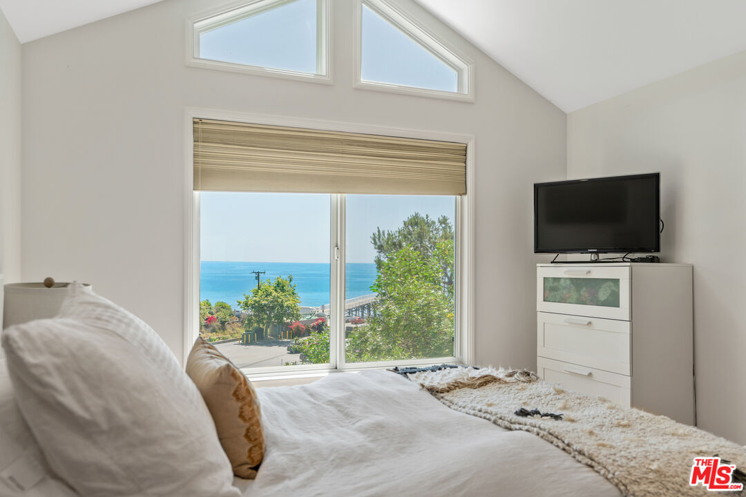 99 Paradise Cove Road Malibu, CA 90265 - Photo 10 of 26 a bedroom with a bed and a flat screen tv
