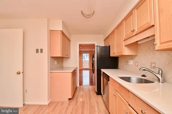 a kitchen with a sink a refrigerator and cabinets