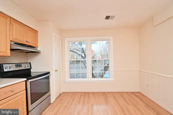 a kitchen with a wooden floor a stove and a window