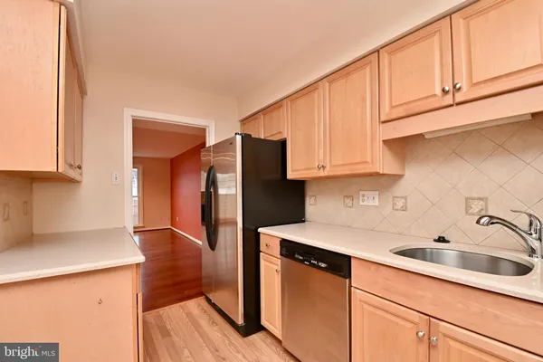 a kitchen with stainless steel appliances granite countertop a sink a refrigerator and cabinets