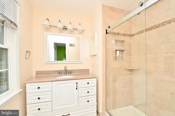 a bathroom with a sink vanity granite and a mirror
