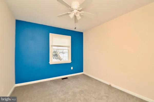 an empty room with a window and a ceiling fan