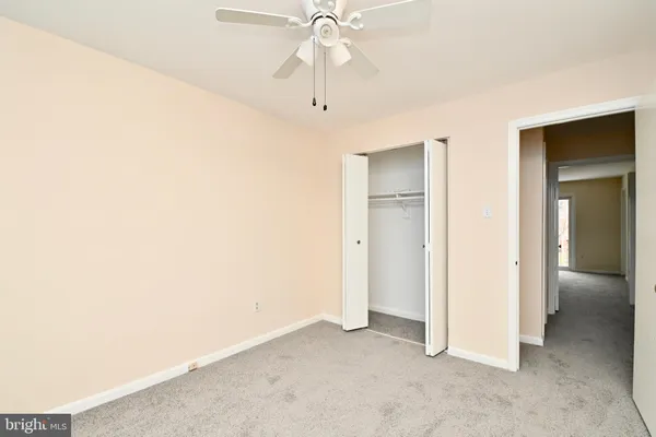 an empty room with fan and entryway