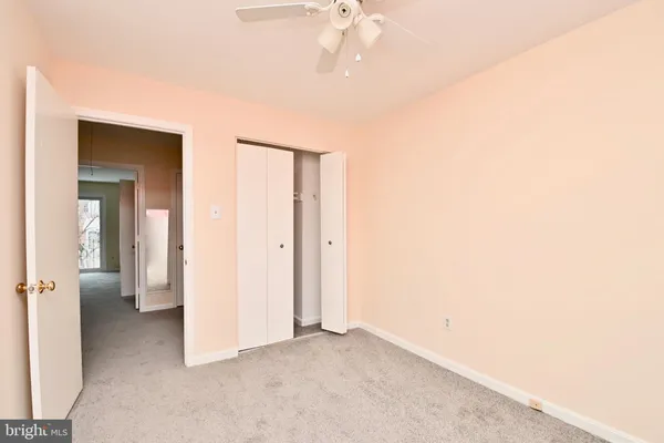 a view of a room with a stylish ceiling fan and entryway