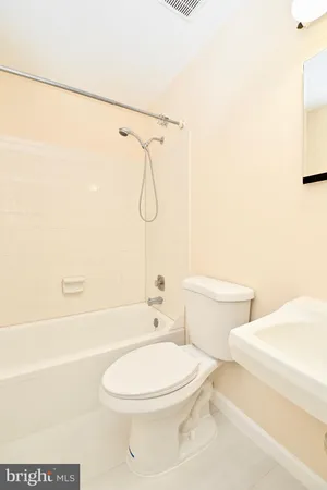 a white toilet and tub sitting next to a bathroom sink