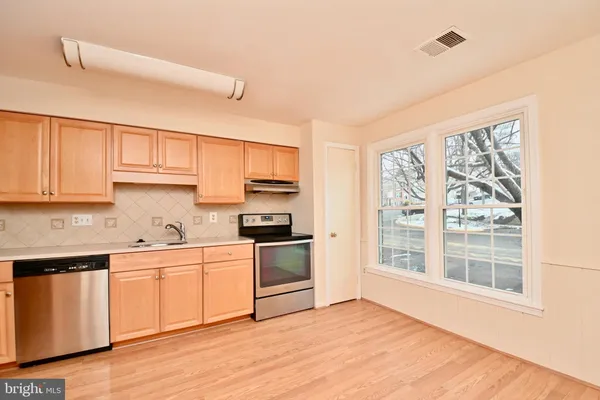 a kitchen with stainless steel appliances a stove top oven sink and cabinets