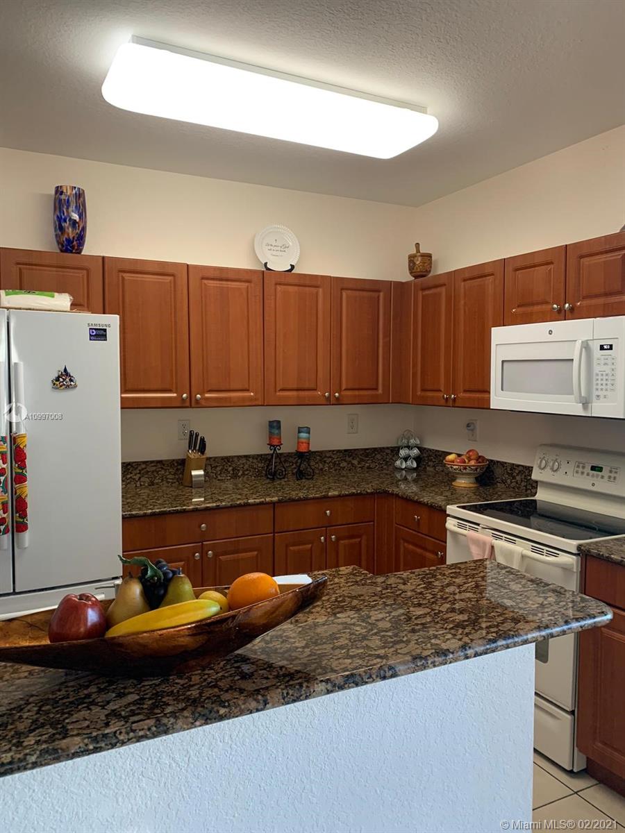 9155 Southwest 227th Street, Unit 10 Cutler Bay, FL 33190 - Photo 4 of 7 a kitchen with stainless steel appliances granite countertop a sink and a stove