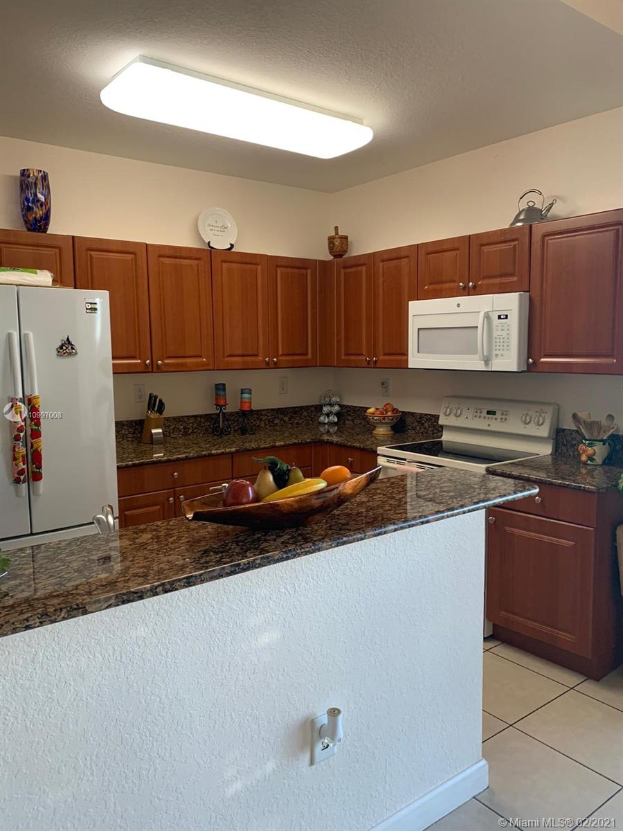 9155 Southwest 227th Street, Unit 10 Cutler Bay, FL 33190 - Photo 5 of 7 a kitchen with stainless steel appliances granite countertop a sink refrigerator and stove