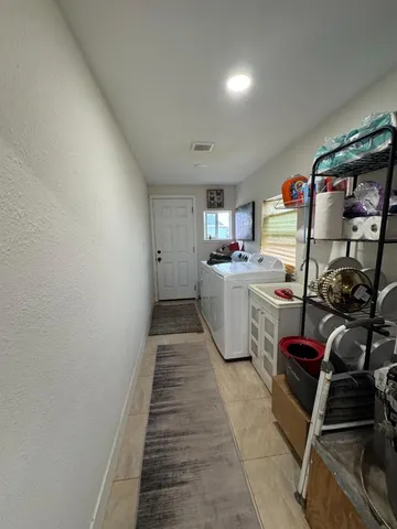 a living room with furniture kitchen area and a window