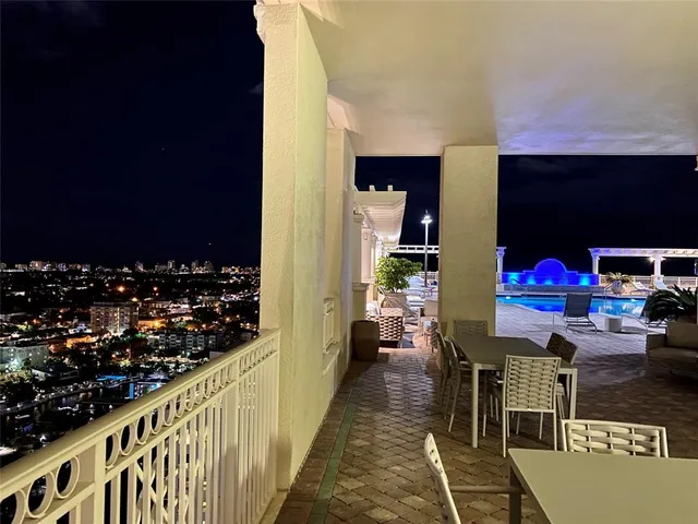 a living room with stainless steel appliances furniture and a kitchen view