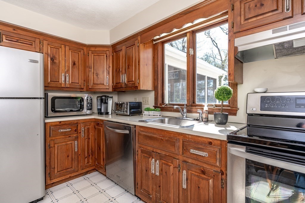 113 Gayland Road Needham, MA 02492 - Photo 6 of 32 a kitchen with a sink stove and cabinets