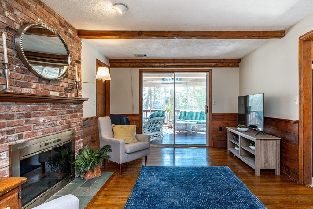 113 Gayland Road Needham, MA 02492 - Photo 10 of 32 a living room with furniture a fireplace and a floor to ceiling window